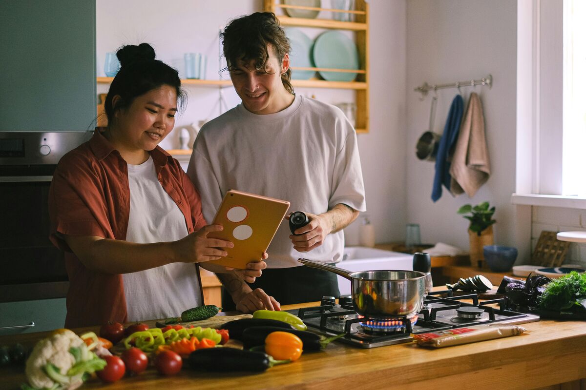 ipadでレシピを見ながら料理をする2人