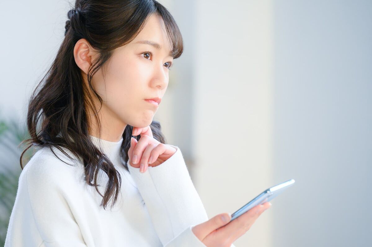 化粧品をスマホで選ぶ女性