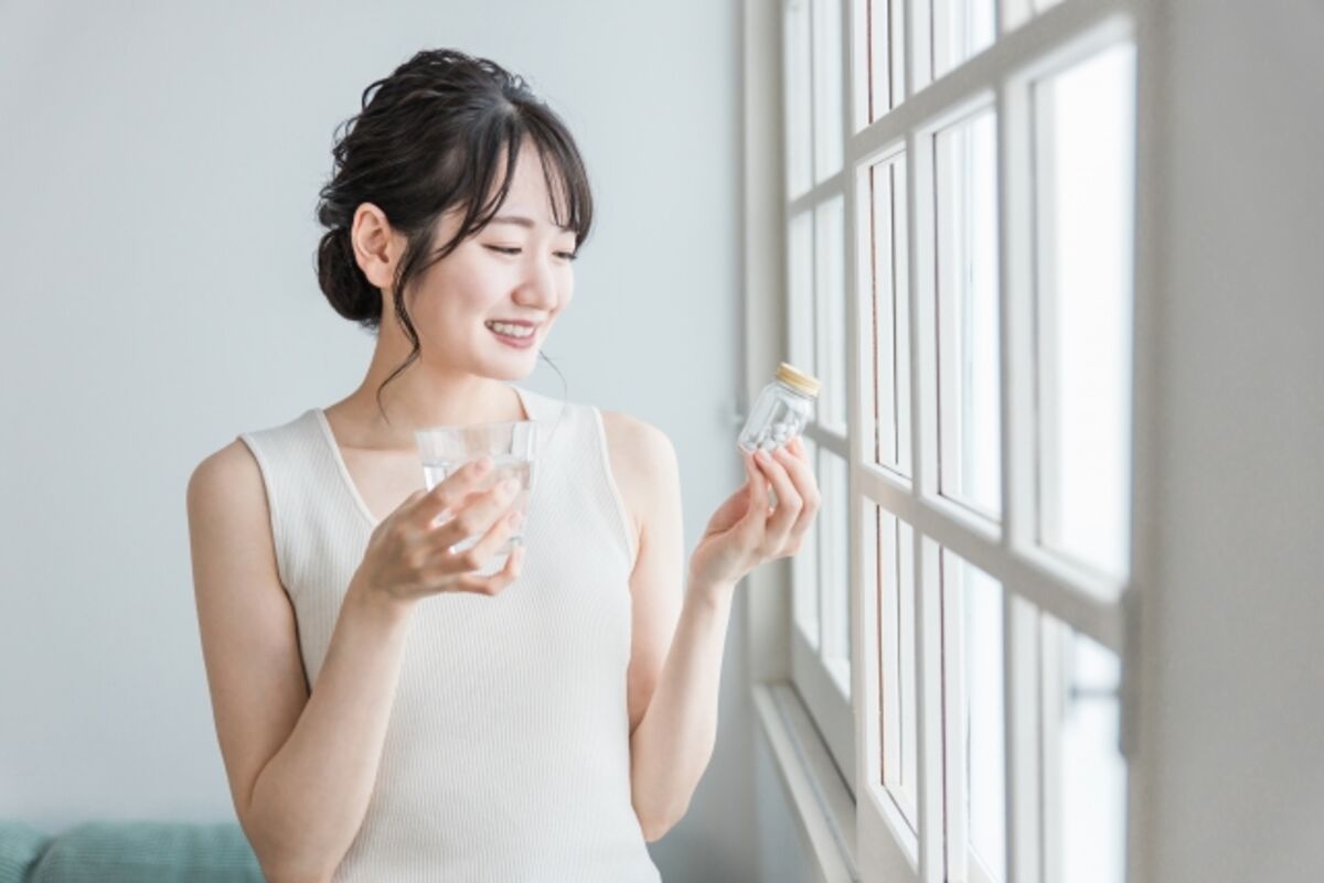 サプリメントを飲む女性