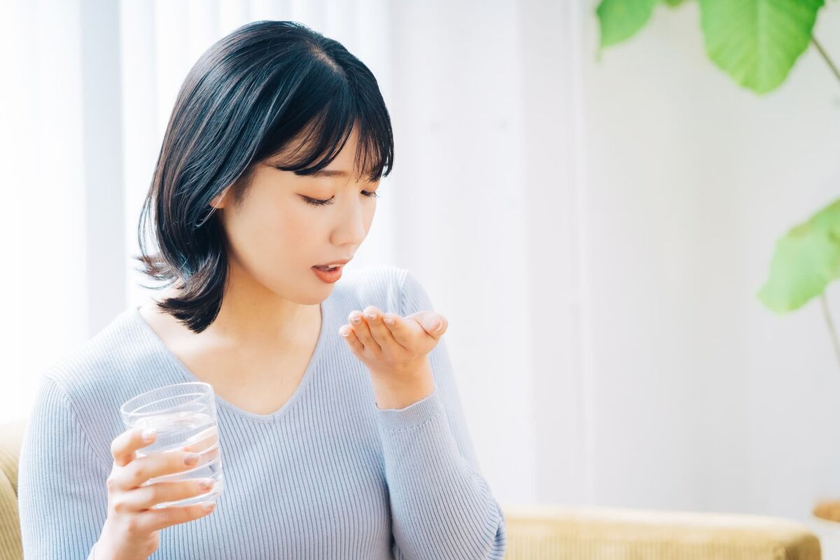 サプリを飲む女性