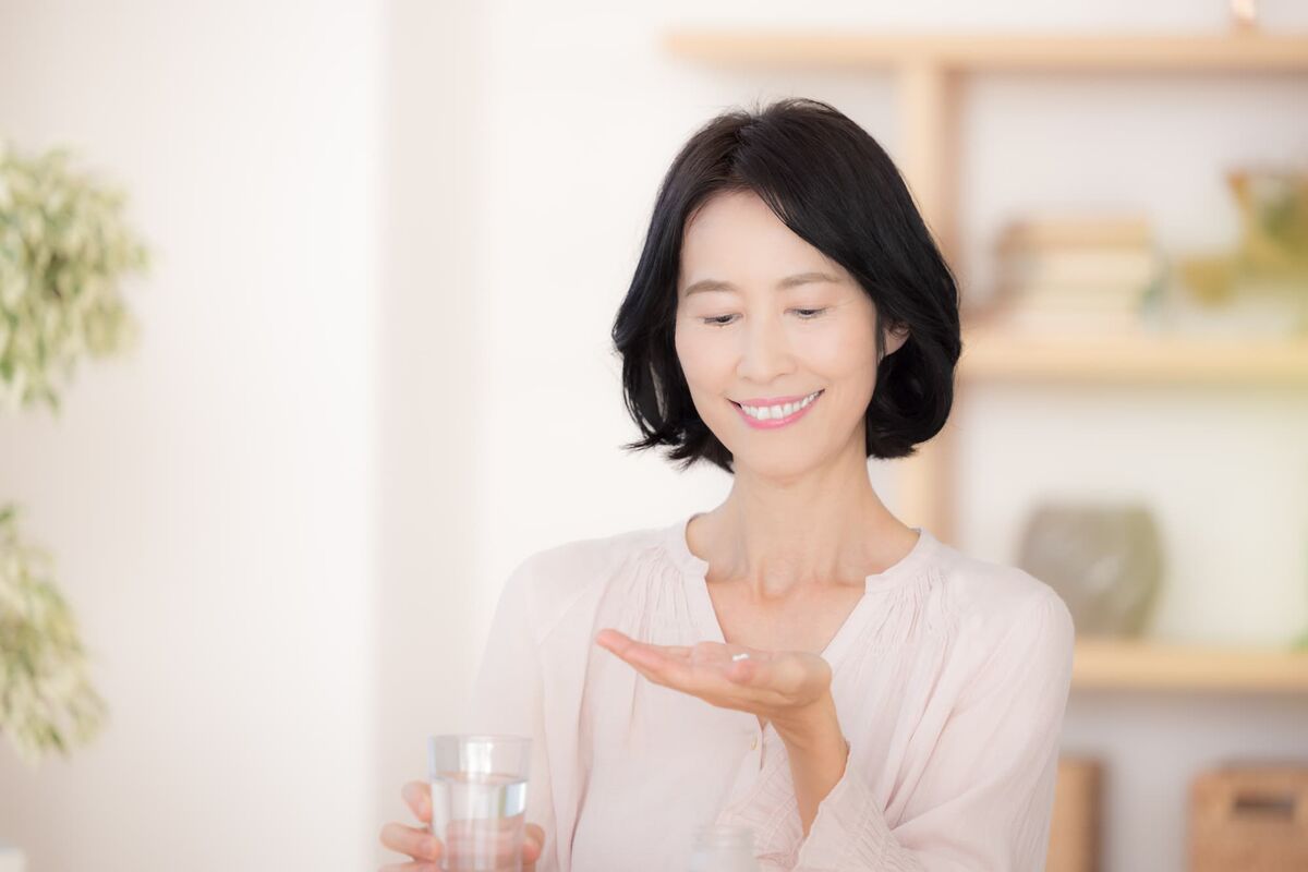 サプリメントを飲む女性